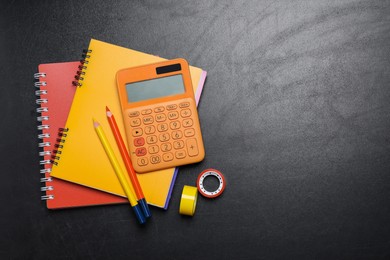 Photo of Flat lay composition with school stationery on blackboard, space for text