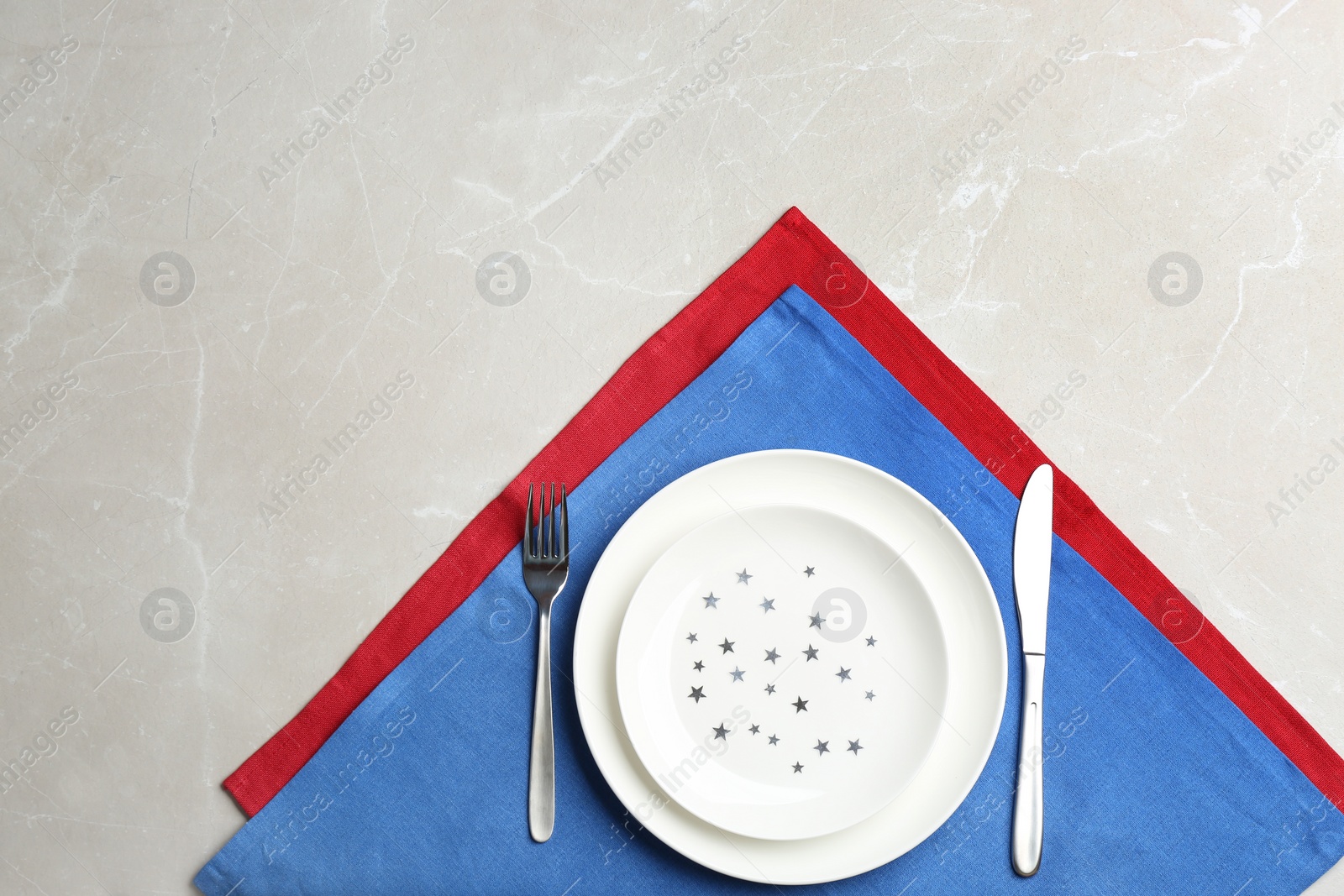 Photo of Patriotic table setting with traditional USA colors on grey background, flat lay. Space for text