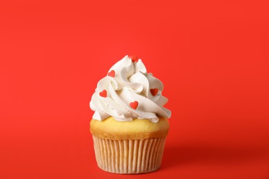 Photo of Tasty cupcake for Valentine's Day on red background