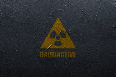 Radioactive sign on black textured wall. Hazard symbol