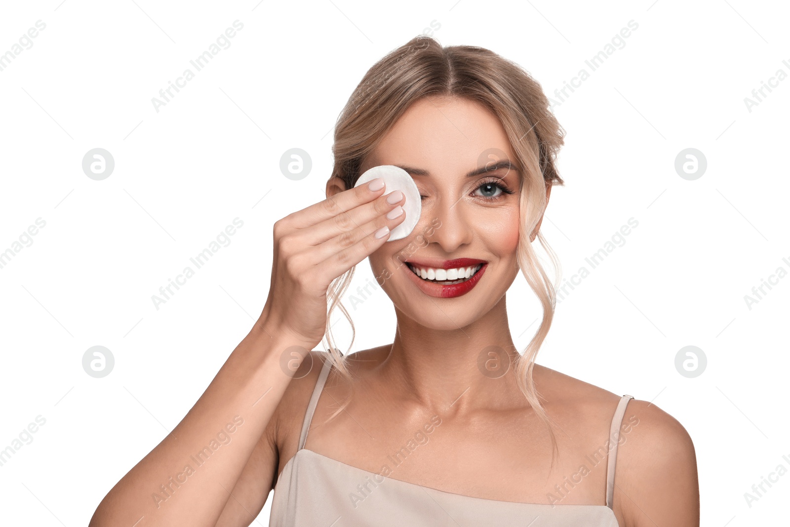 Photo of Smiling woman removing makeup with cotton pad on white background