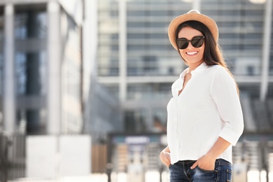 Photo of Beautiful woman with sunglasses on city street. Space for text