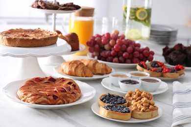 Photo of Variety of snacks on white marble table in buffet style indoors