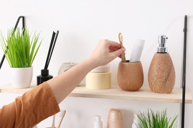 Photo of Bath accessories. Woman organizing personal care products indoors, closeup