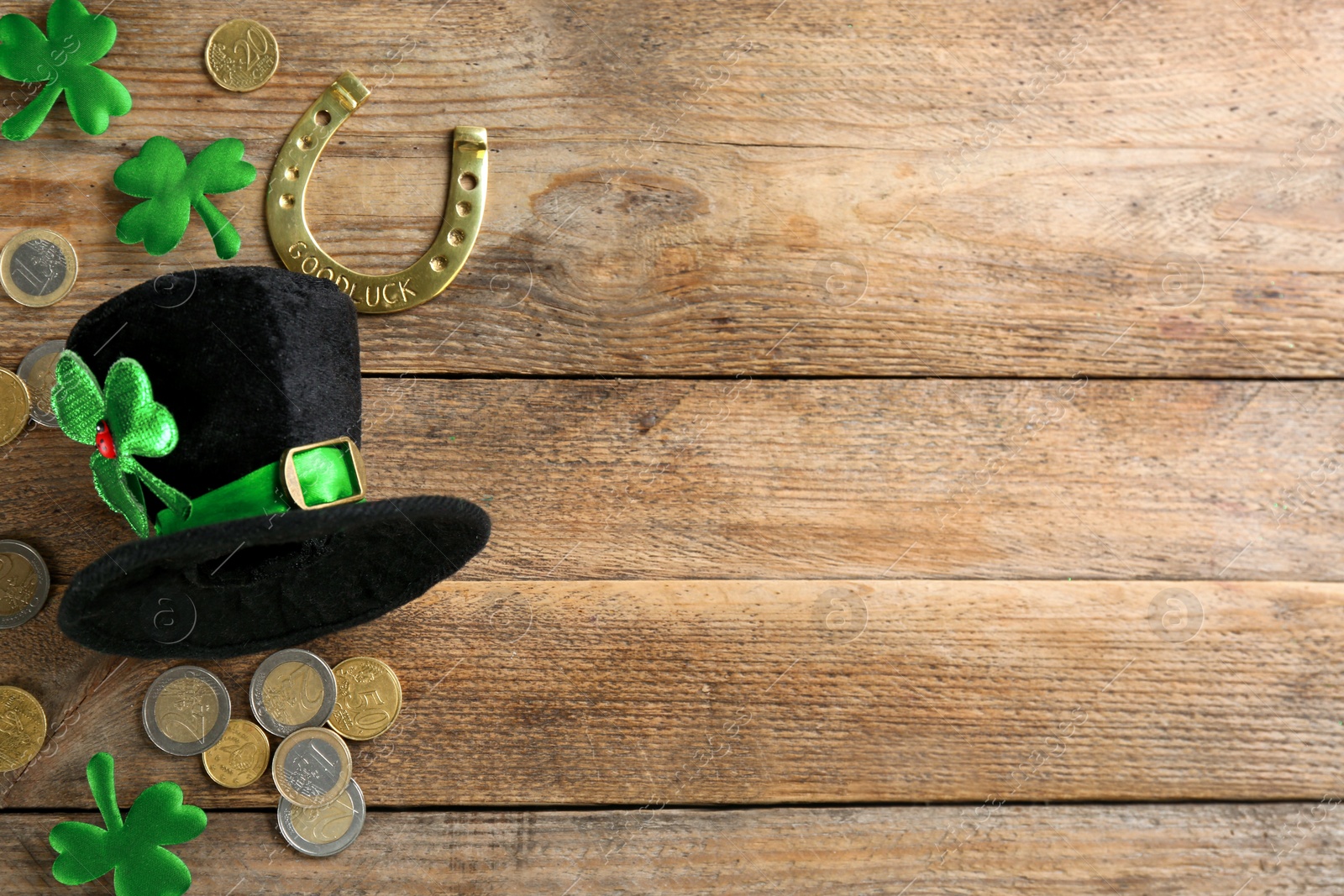 Photo of Leprechaun's hat and St. Patrick's day decor on wooden background, flat lay. Space for text