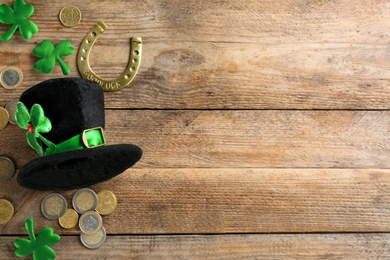 Photo of Leprechaun's hat and St. Patrick's day decor on wooden background, flat lay. Space for text