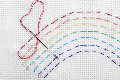 Photo of Canvas with embroidered rainbow and needle, top view