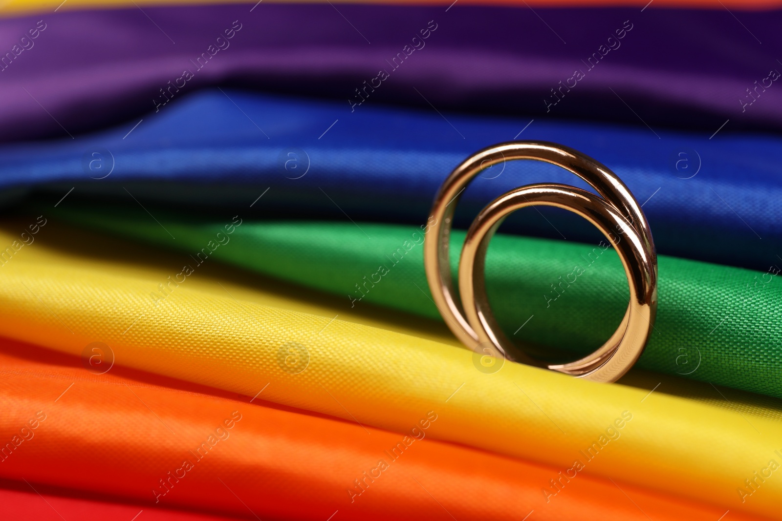 Photo of Wedding rings on rainbow LGBT flag, closeup