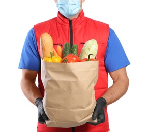 Photo of Courier in medical mask holding paper bag with food on white background, closeup. Delivery service during quarantine due to Covid-19 outbreak