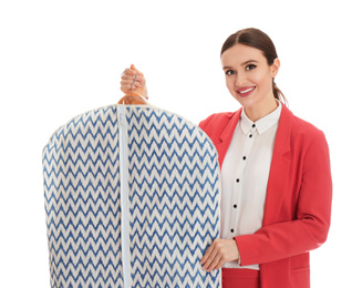 Young woman holding hanger with clothes in garment cover on white background. Dry-cleaning service