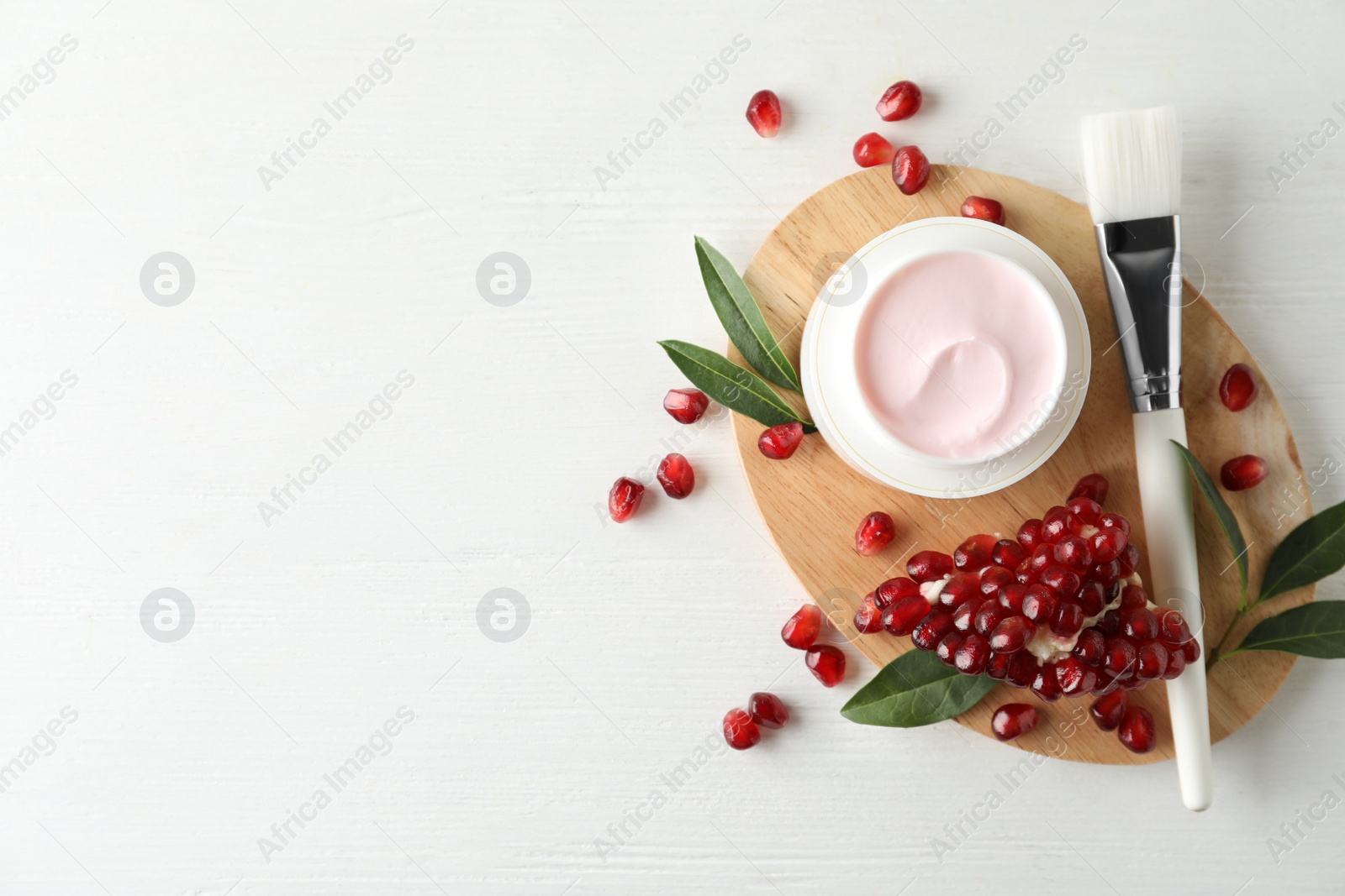 Photo of Flat lay composition with natural pomegranate facial mask on white wooden table. Space for text