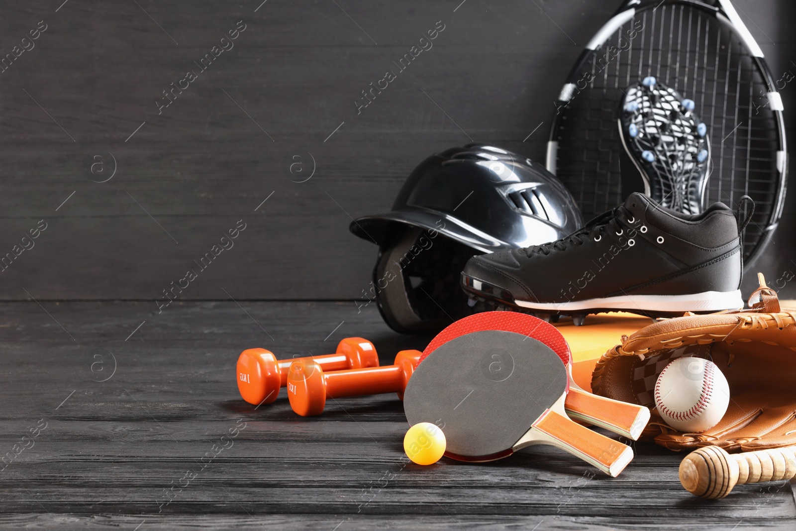 Photo of Many different sports equipment on dark grey wooden table, space for text