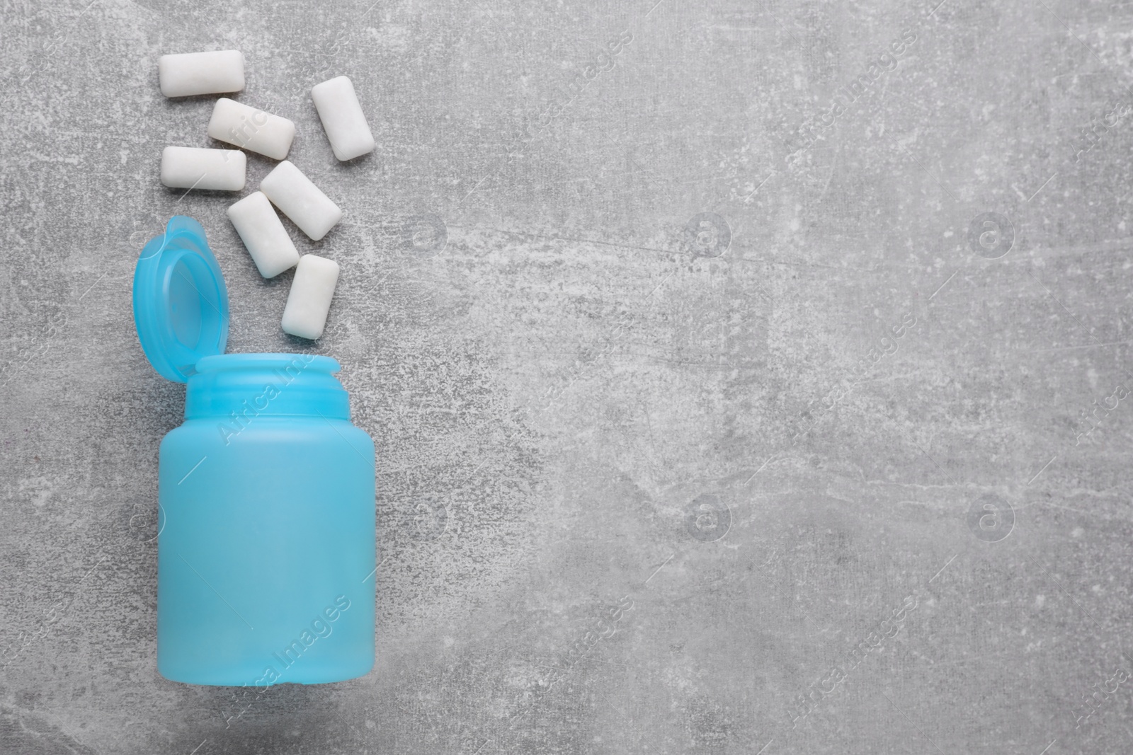 Photo of Jar with chewing gums on light grey table, flat lay. Space for text