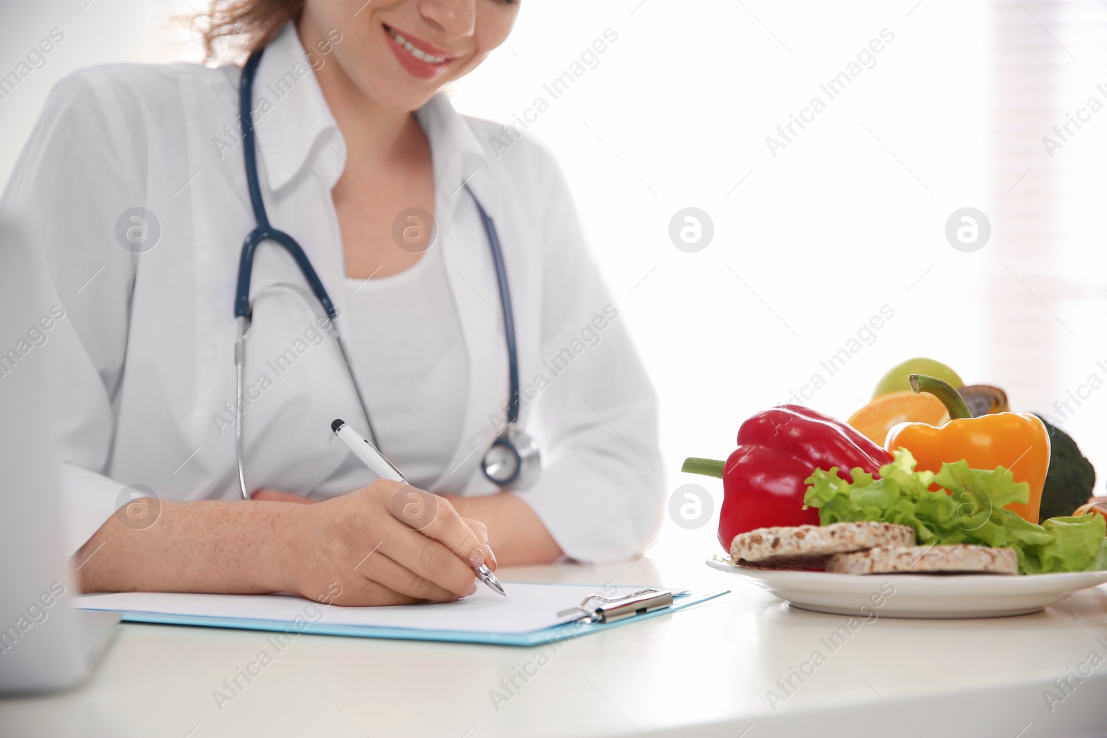 Photo of Nutritionist working at desk in office, closeup