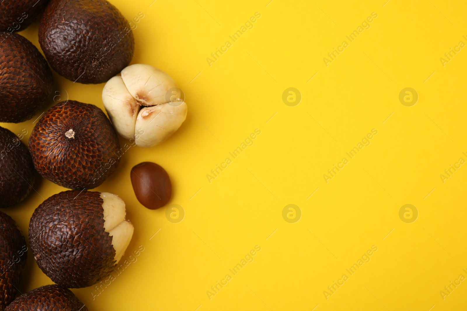 Photo of Fresh salak fruits on yellow background, flat lay. Space for text