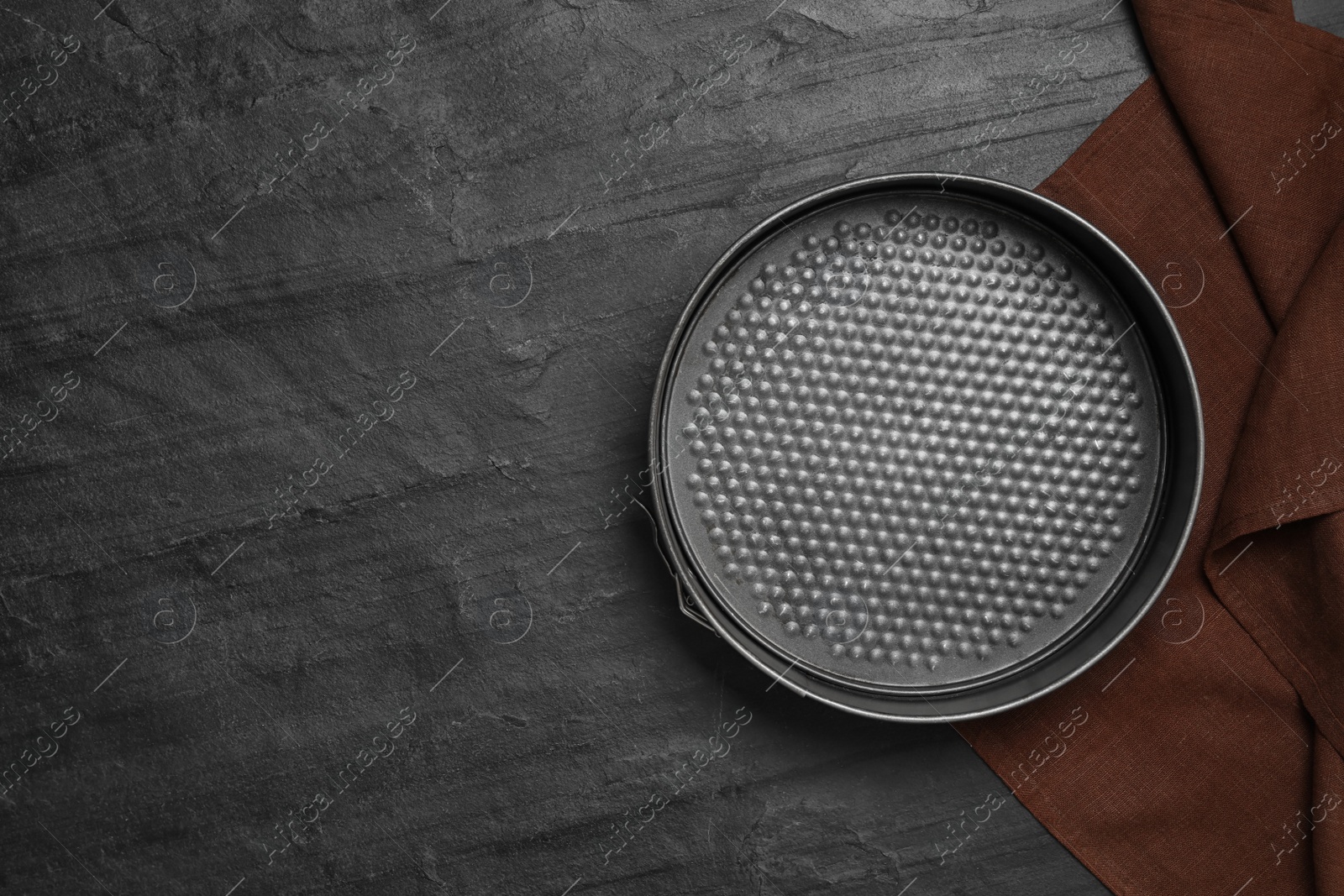 Photo of Baking dish and brown cloth on black table, flat lay with space for text. Cooking utensil