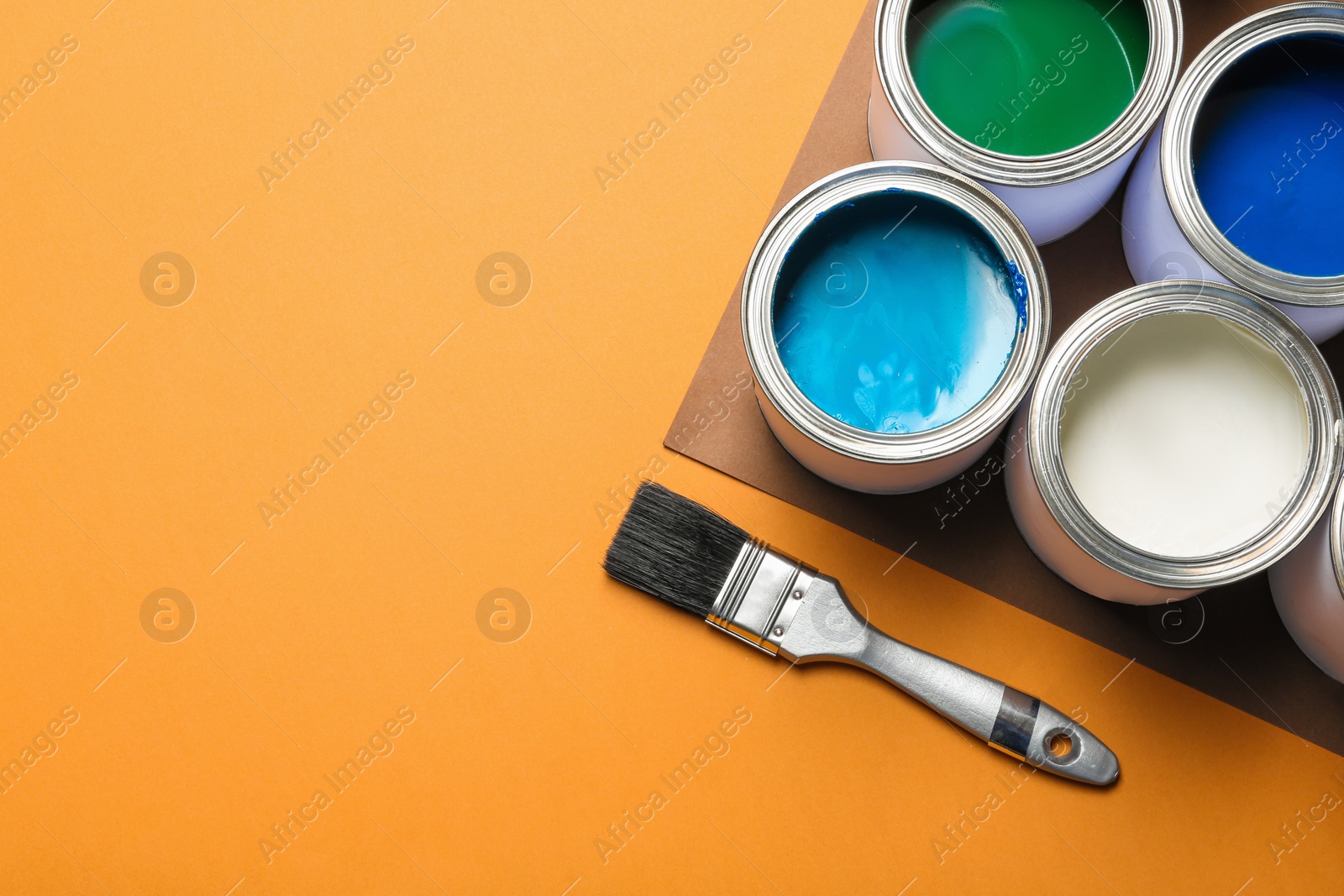 Photo of Flat lay composition with paint cans and space for text on color background