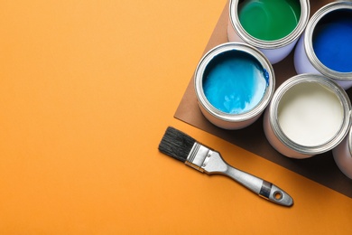 Flat lay composition with paint cans and space for text on color background