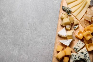 Photo of Cheese plate on grey table, top view. Space for text