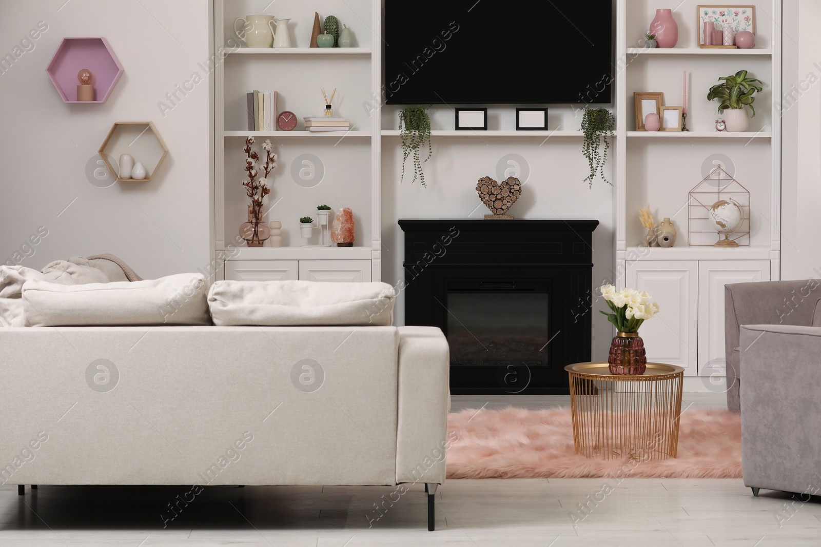 Photo of Stylish room interior with beautiful fireplace, TV set, armchair, sofa and shelves with decor