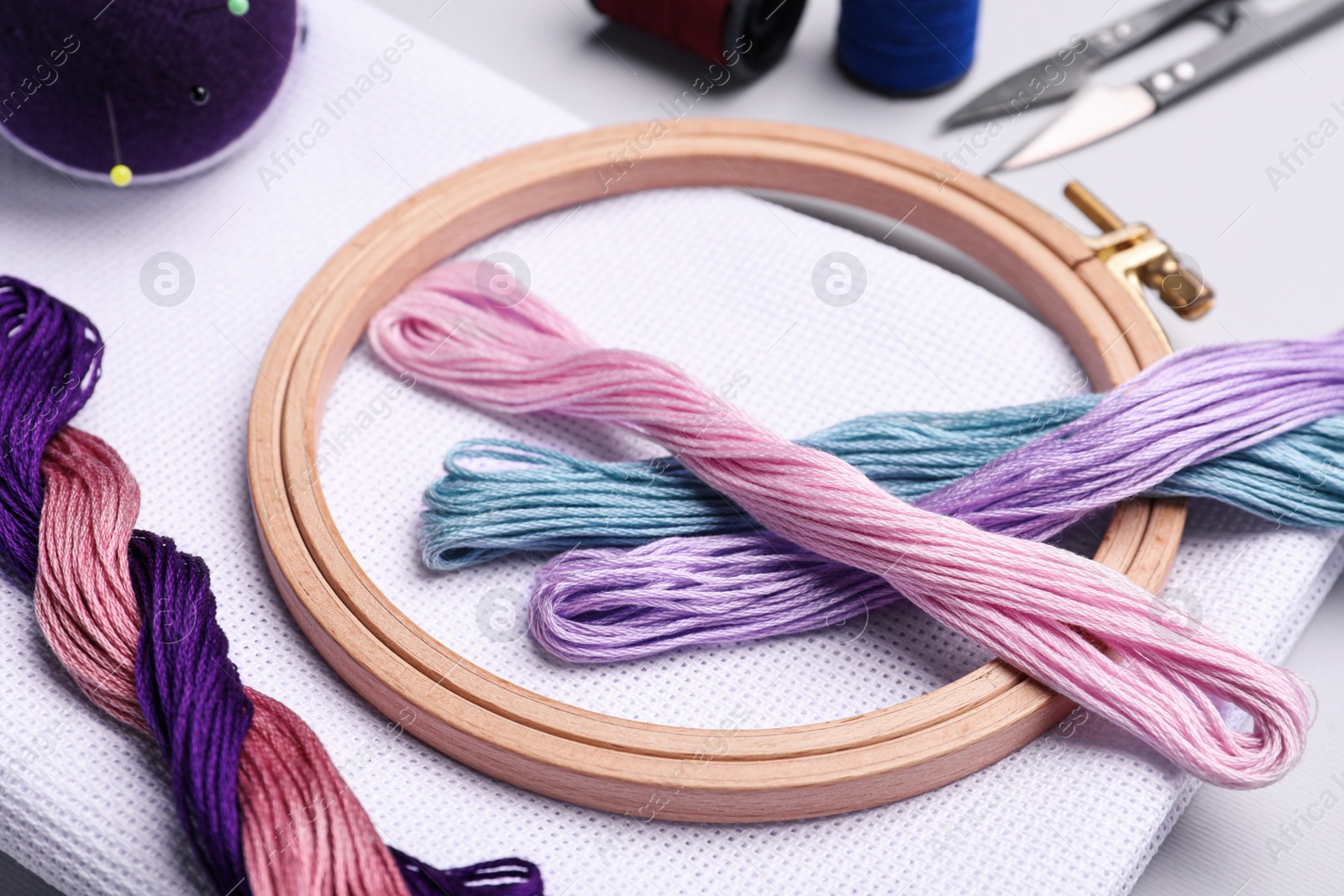 Photo of Set of embroidery equipment on light grey background, closeup