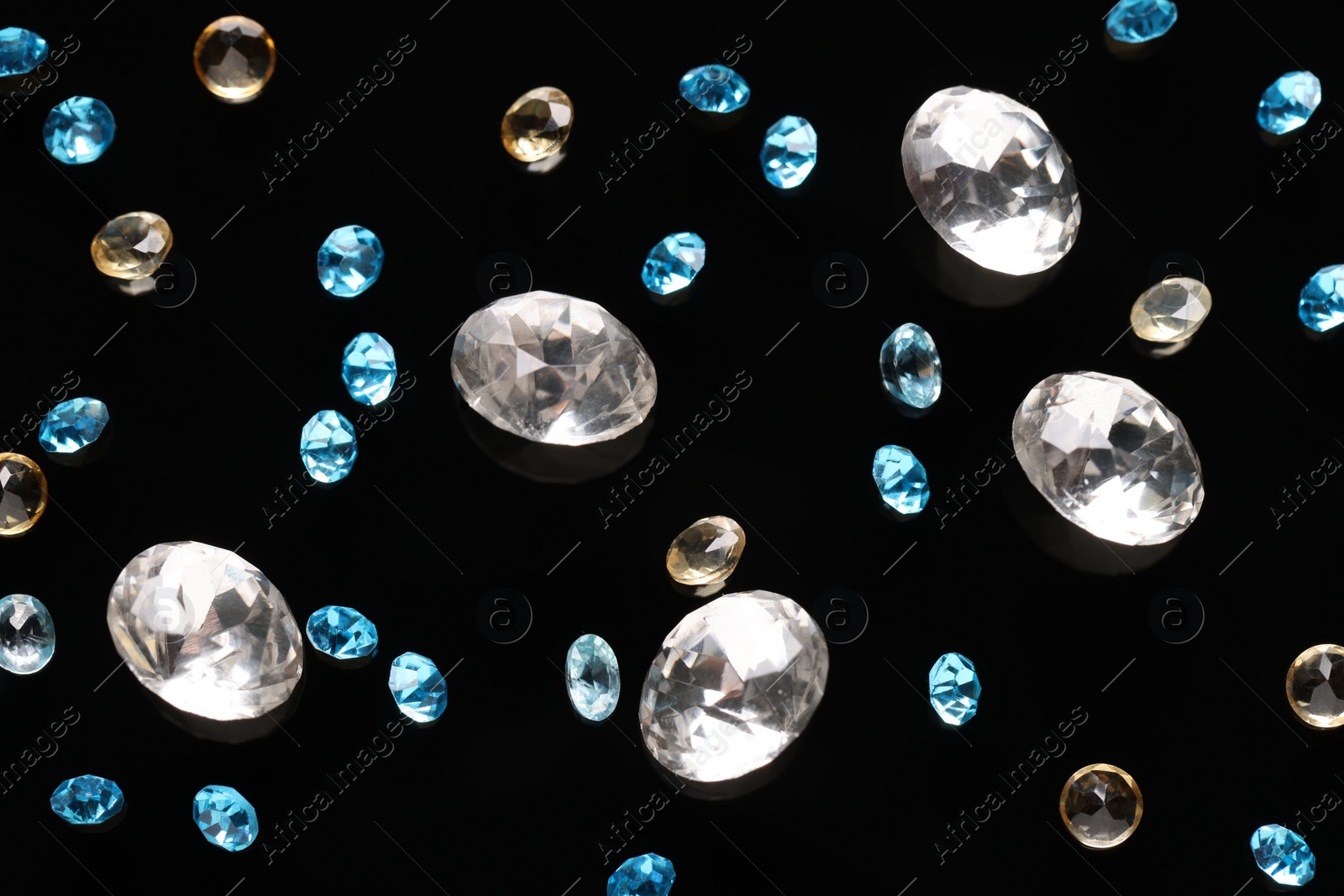 Photo of Different beautiful gemstones for jewelry on black background, flat lay