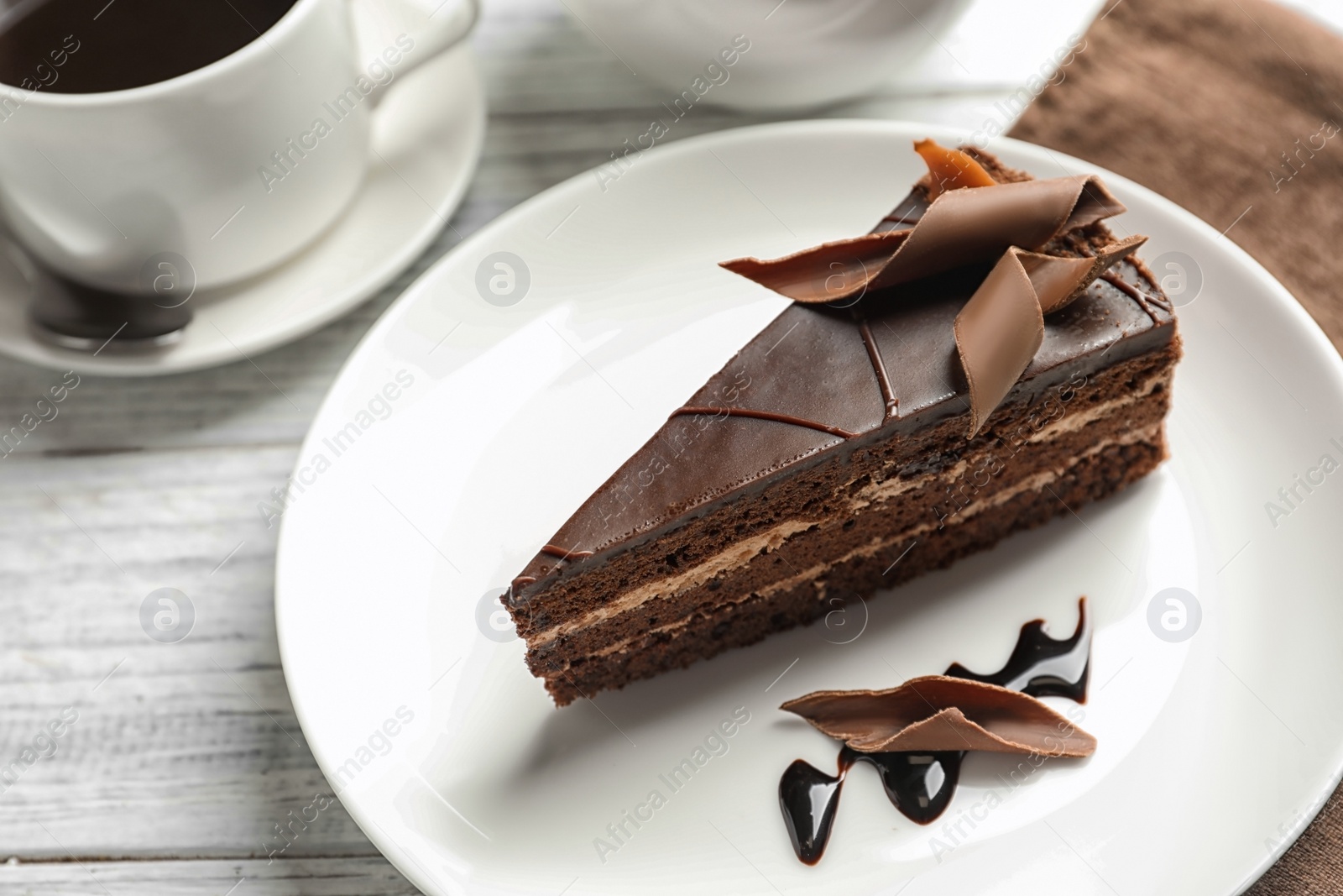 Photo of Plate with slice of homemade chocolate cake served on table