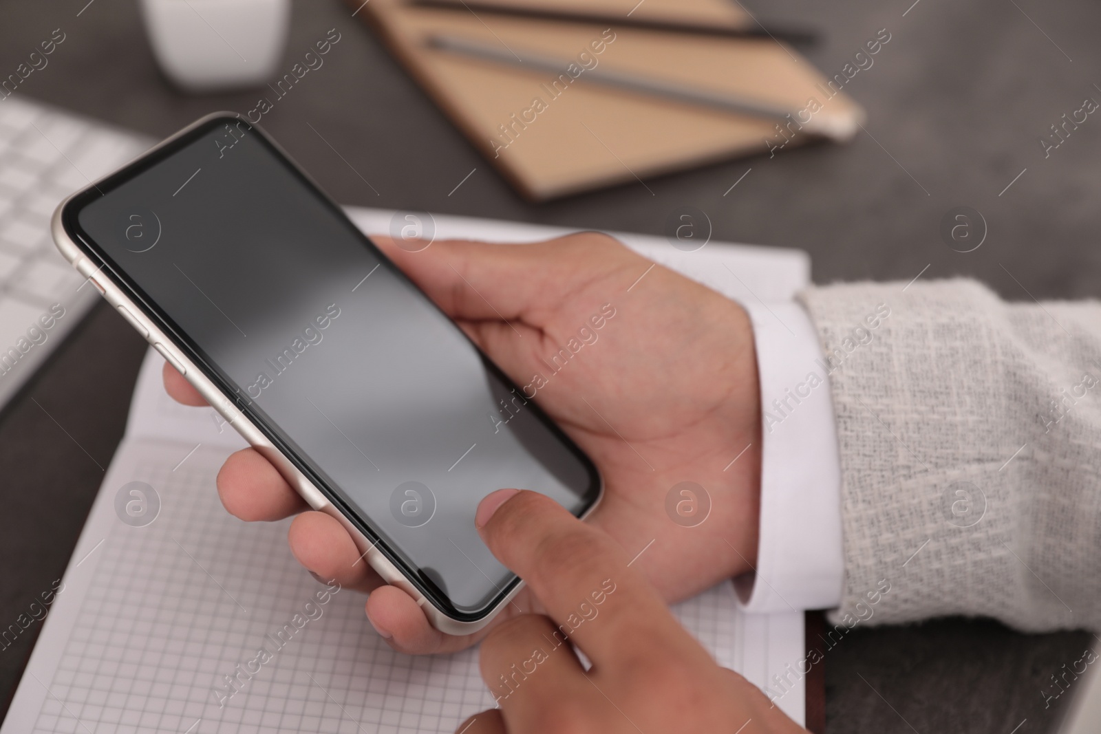 Photo of Man using mobile phone with empty screen at table, closeup