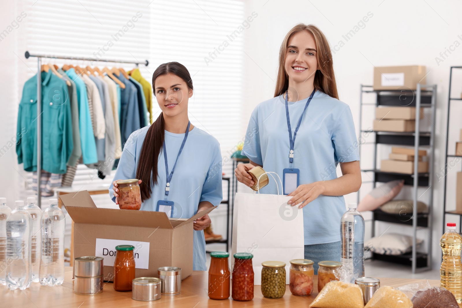 Photo of Volunteers packing food products at table in warehouse