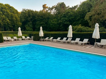 Photo of Outdoor swimming pool in luxury hotel on sunny summer day. Time for relax