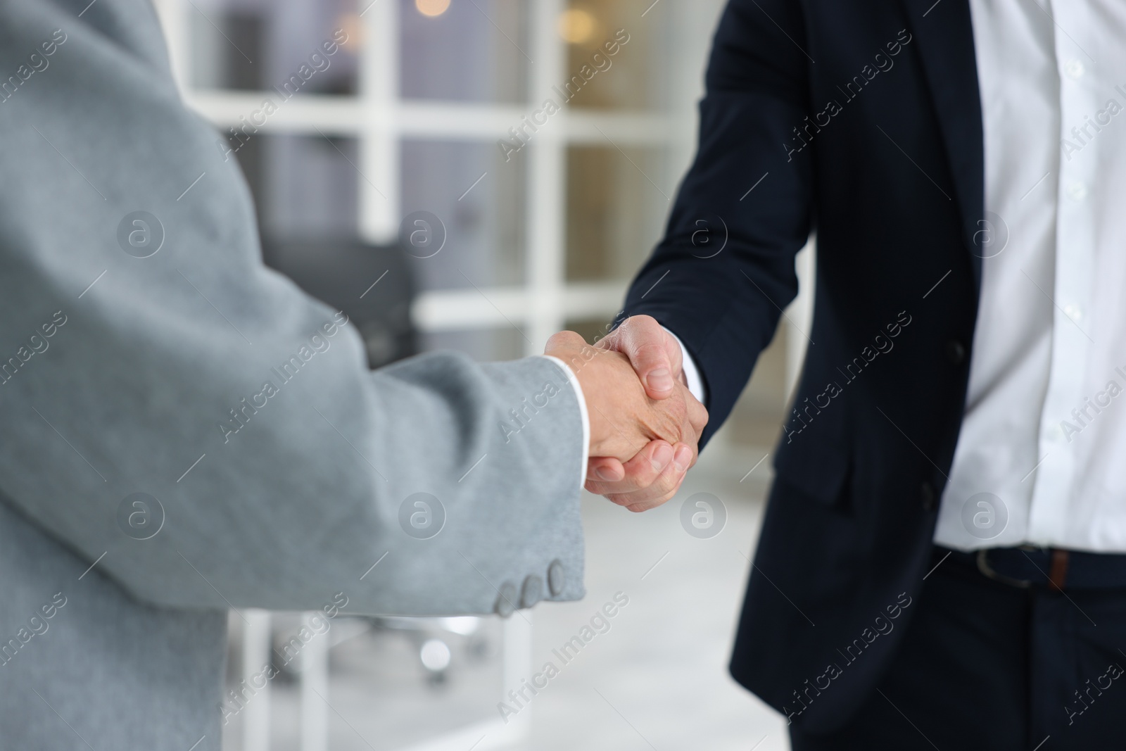 Photo of Lawyer shaking hands with client in office, closeup