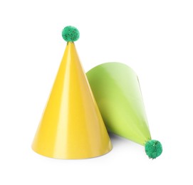 Two colorful party hats with pompoms isolated on white