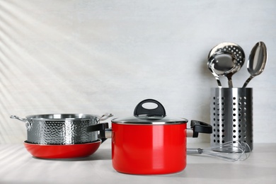 Set of clean cookware on table against light background