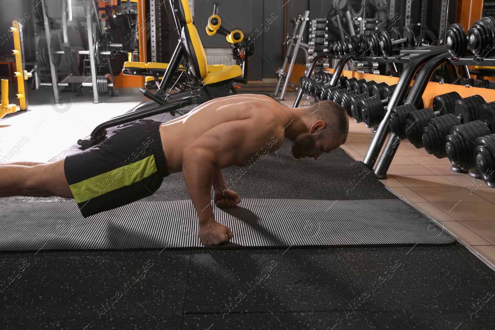 Photo of Strong man doing plank exercise in gym