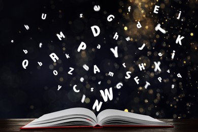 Image of Letters flying out from open book on wooden table