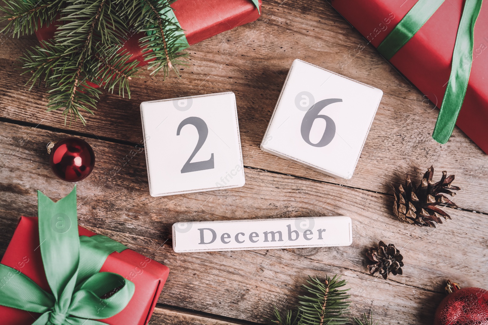 Photo of Flat lay composition with block calendar and gifts on wooden table. Boxing day