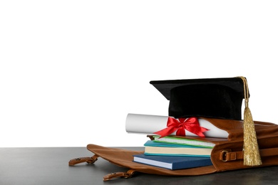 Photo of Briefcase with books, diploma and graduation hat on table against white background