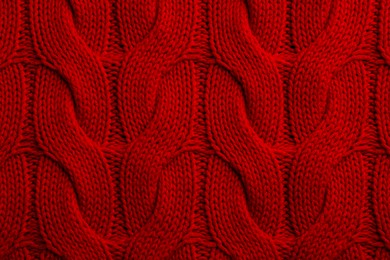 Beautiful red knitted fabric as background, top view