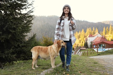 Happy woman and adorable dog in mountains. Traveling with pet