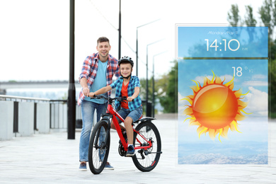 Image of Dad teaching son to ride bicycle outdoors and weather forecast widget. Mobile application