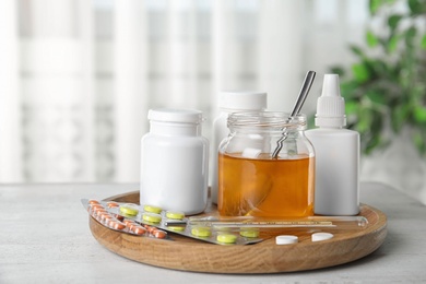 Honey and different cold remedies on white wooden table