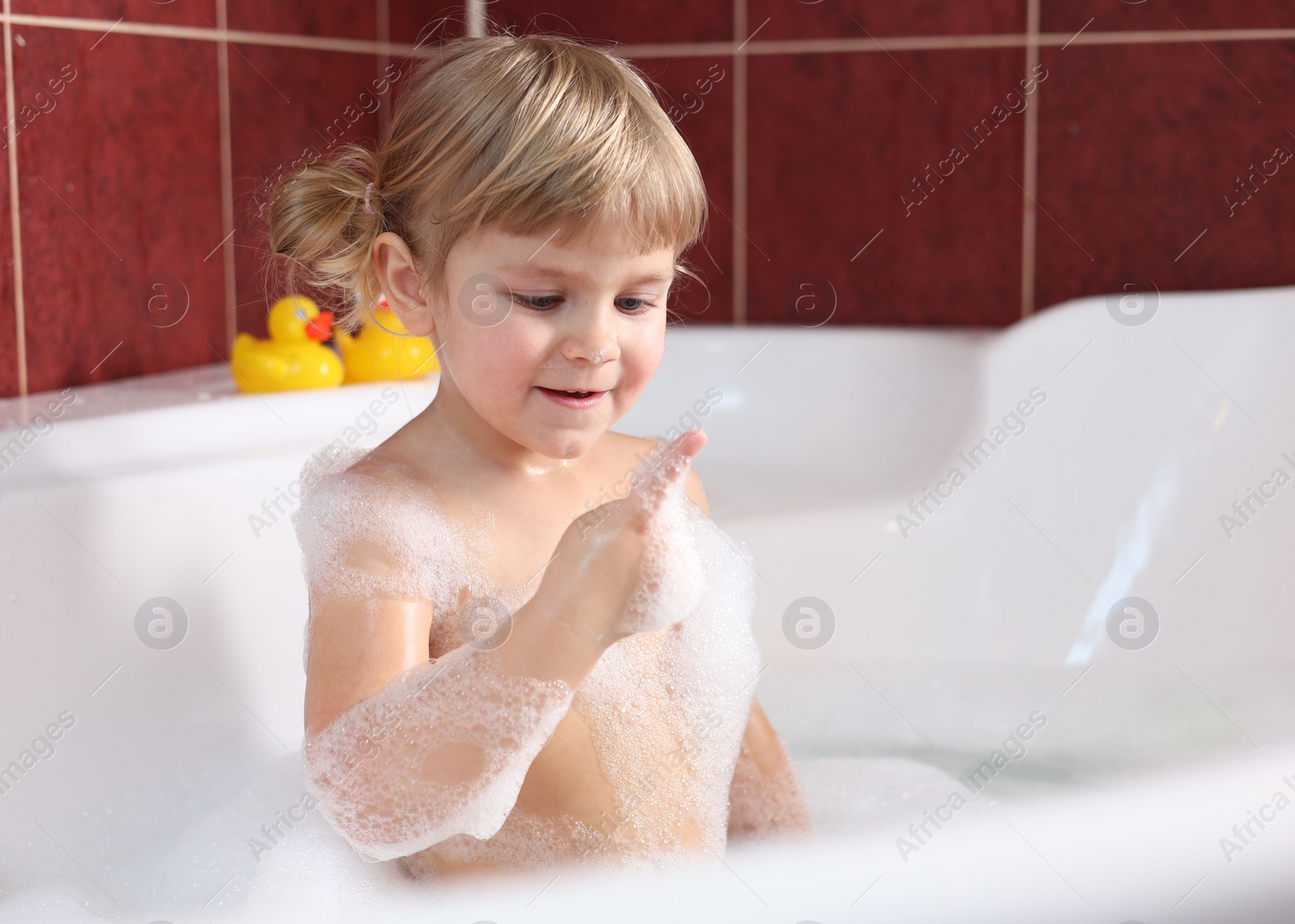 Photo of Happy girl bathing in tub at home