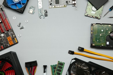 Frame of graphics card and other computer hardware on light background, flat lay. Space for text