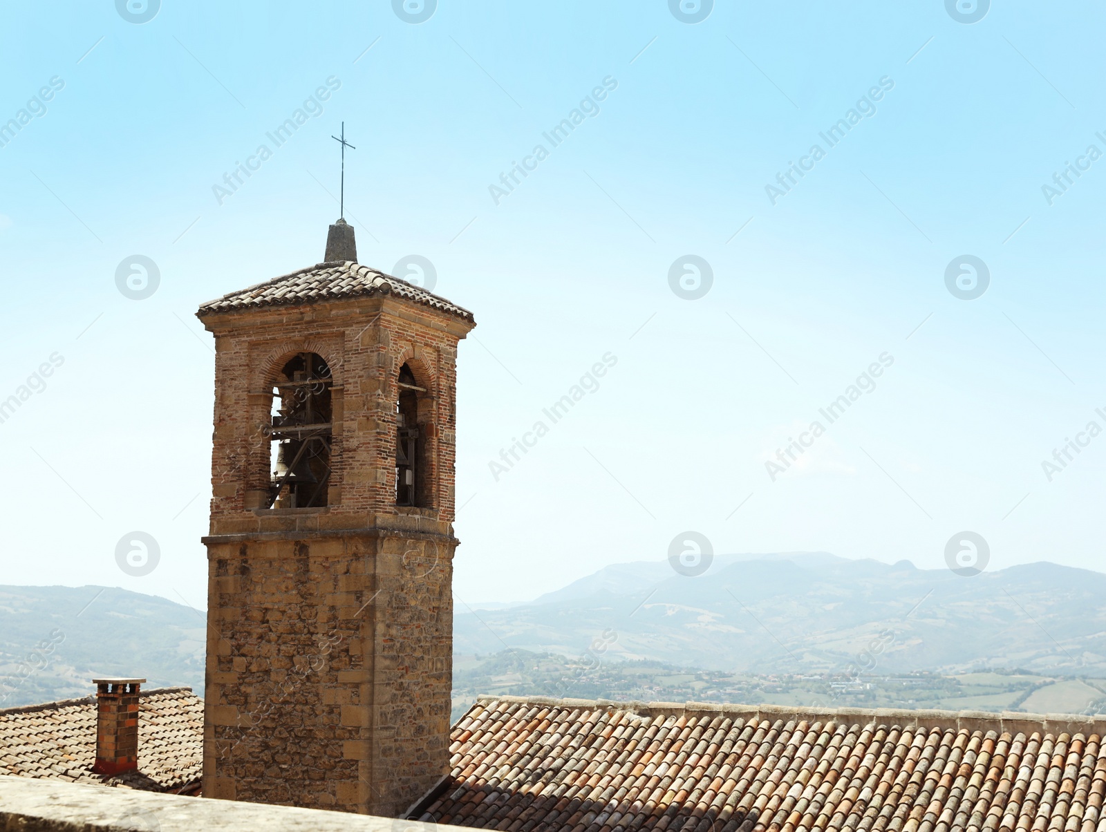 Photo of Picturesque view of city tower and mountains, space for text