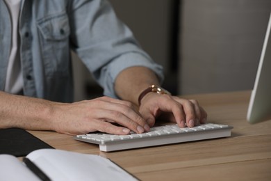 Photo of Man working on computer at table in office, closeup