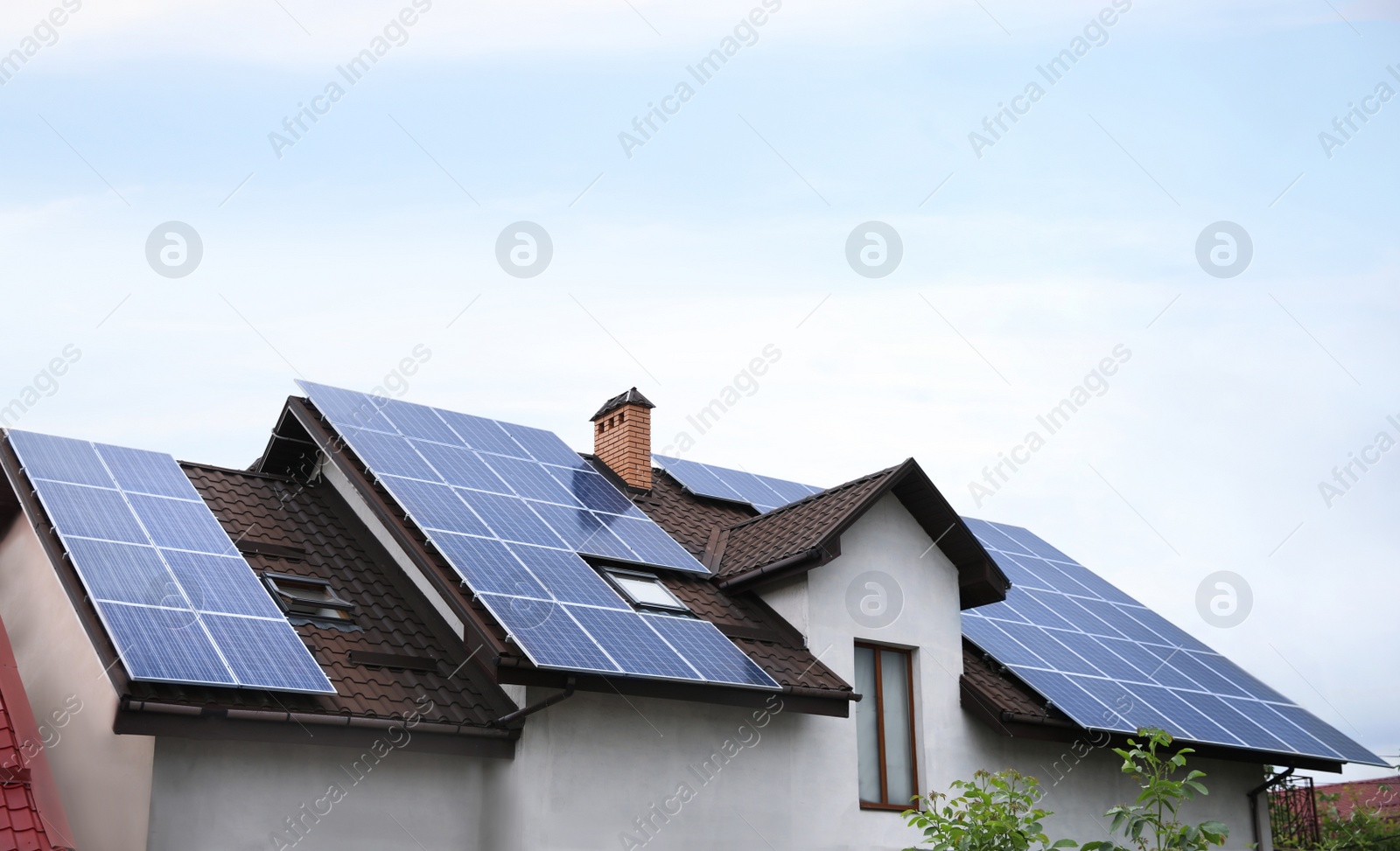 Photo of House with installed solar panels on roof. Alternative energy source