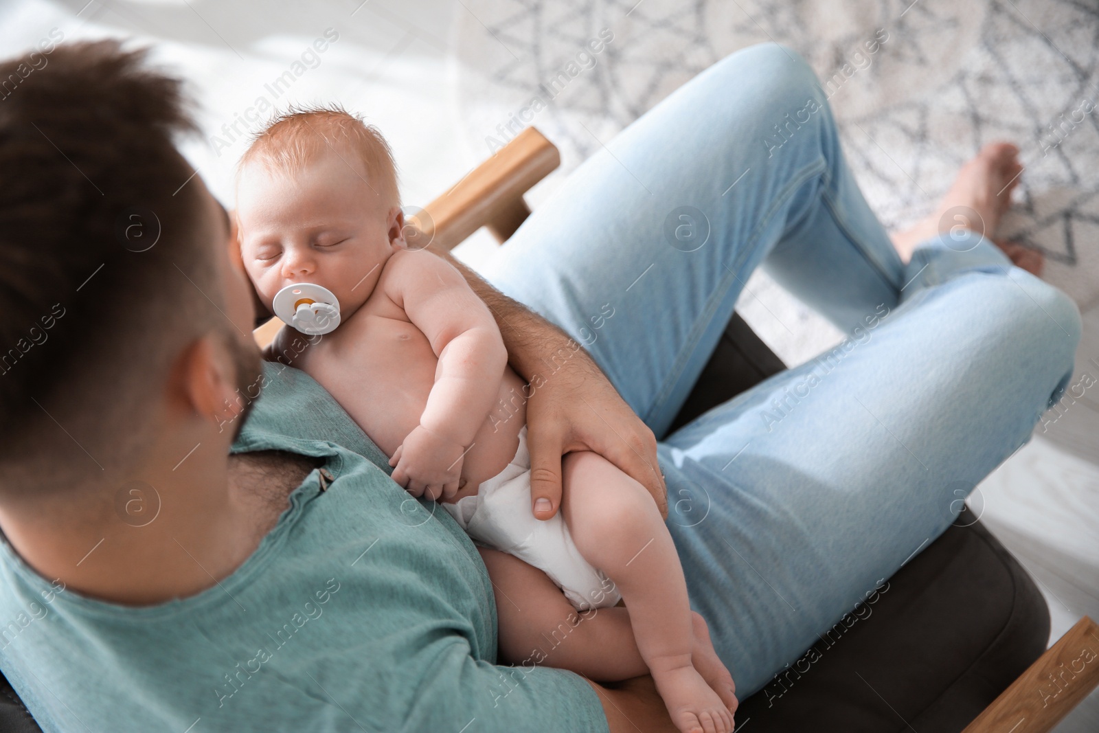 Photo of Father with his newborn son at home, above view