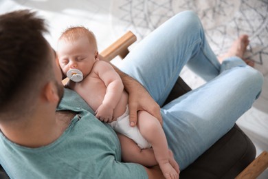 Father with his newborn son at home, above view