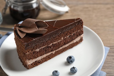 Delicious fresh chocolate cake on wooden table, closeup