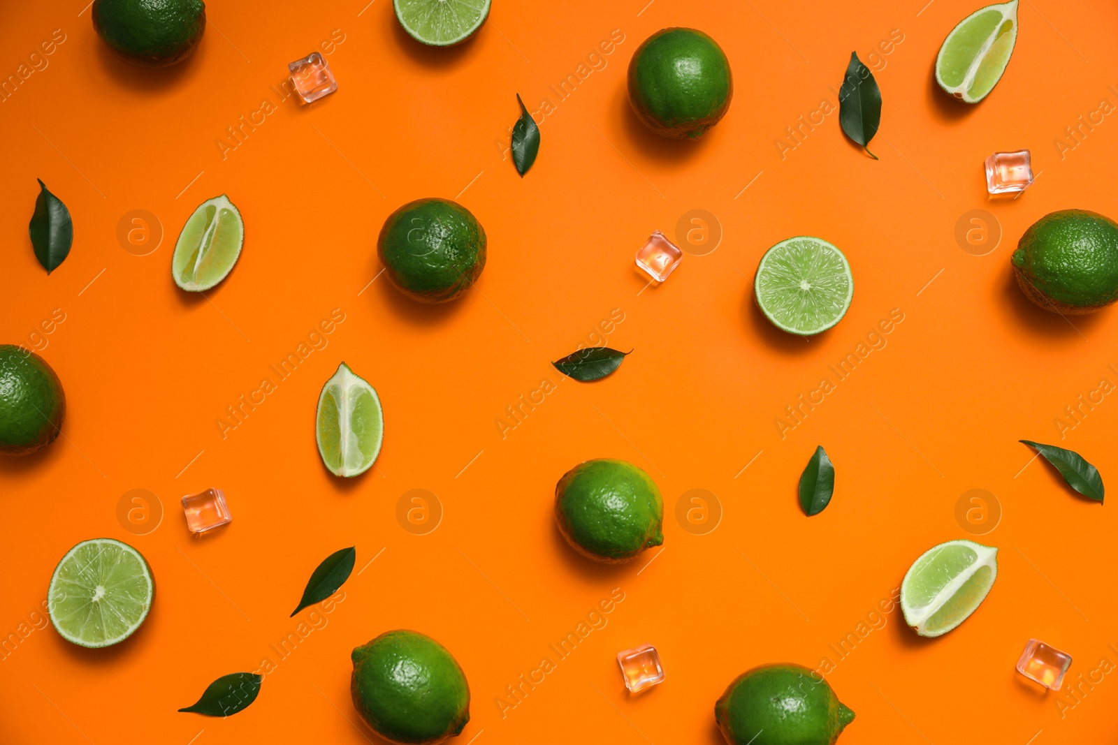 Photo of Flat lay composition with fresh juicy limes and ice cubes on orange background